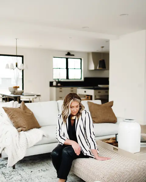 Ashlei sitting on a sofa in a light living room