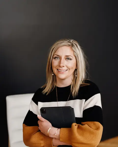 Ashlei smiling in a studio, holding a tablet
