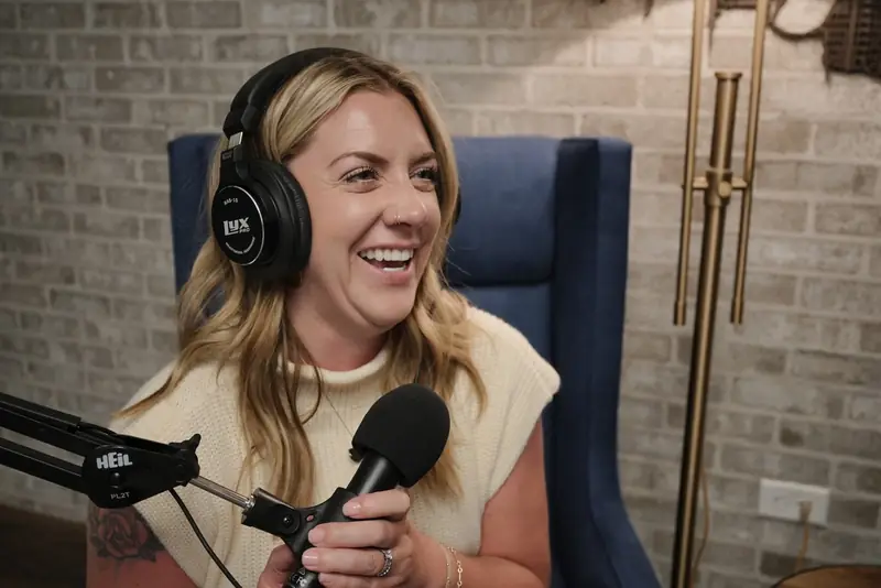 Ashlei laughing at the microphone in headphones while recording HVAC Leaders